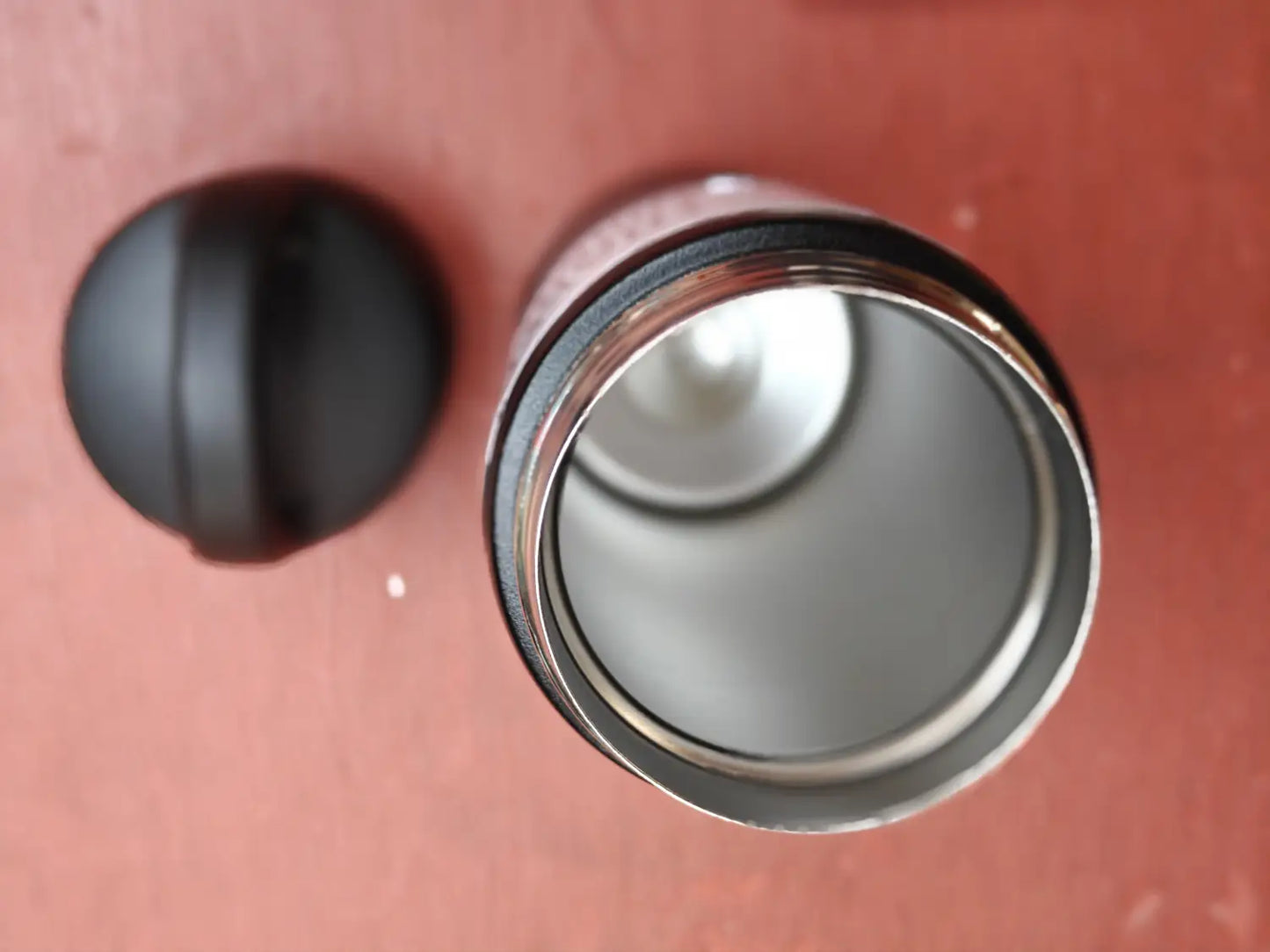 Close-up of a inside double valve tumbler on a red floor