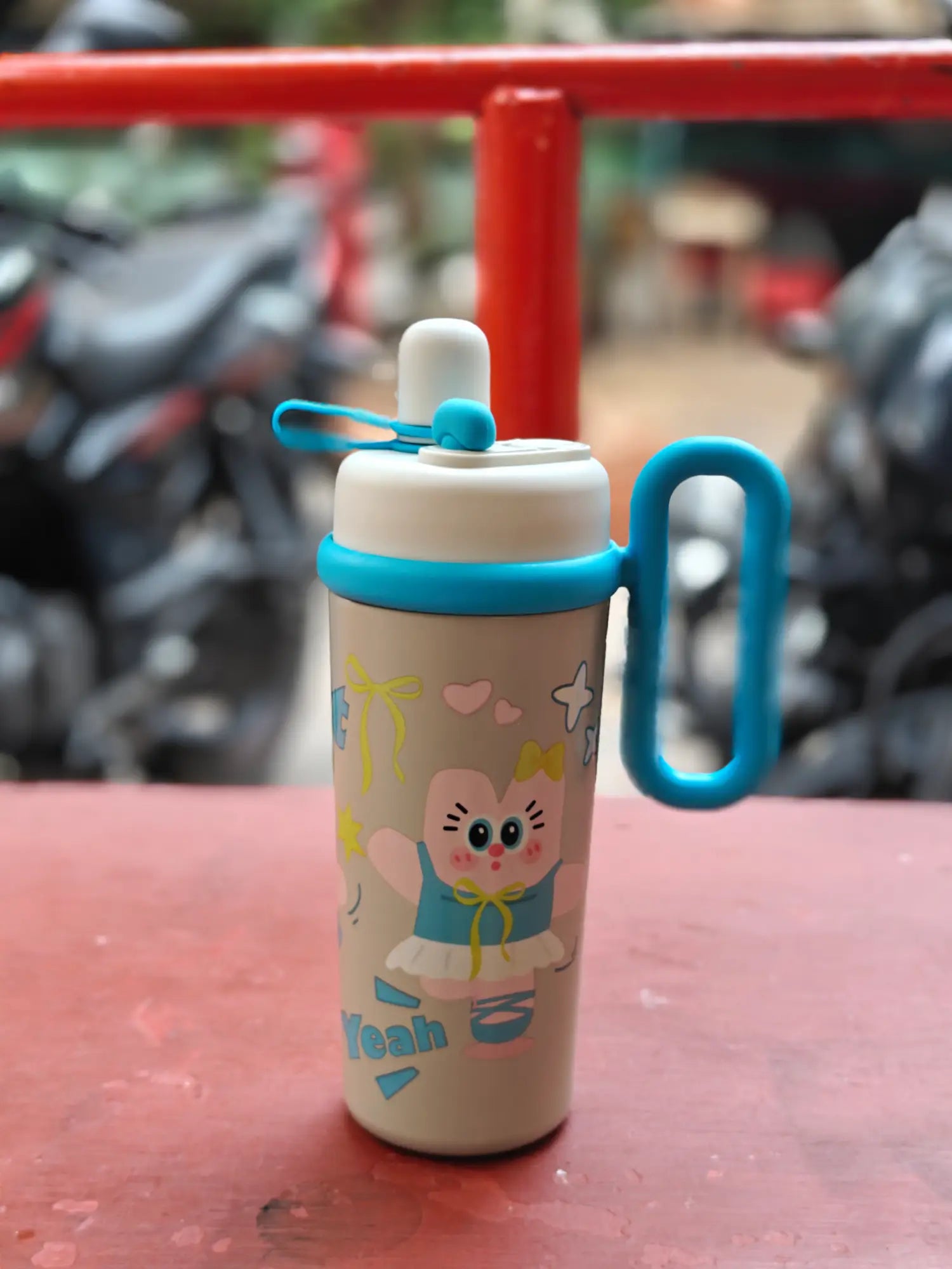 Children's tumbler with cartoon character on a red surface