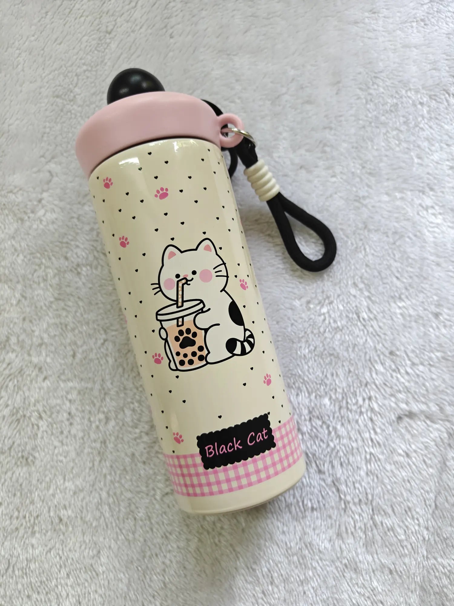 Illustrated water bottle with a cat design on a textured surface