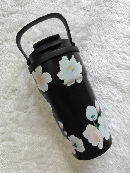 Black tumbler with floral design on a white textured background