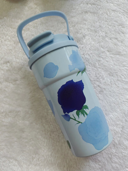 Water bottle with blue floral design on a textured white surface