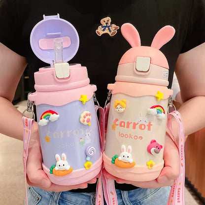 Two pink water bottles with cartoon designs held by a person.