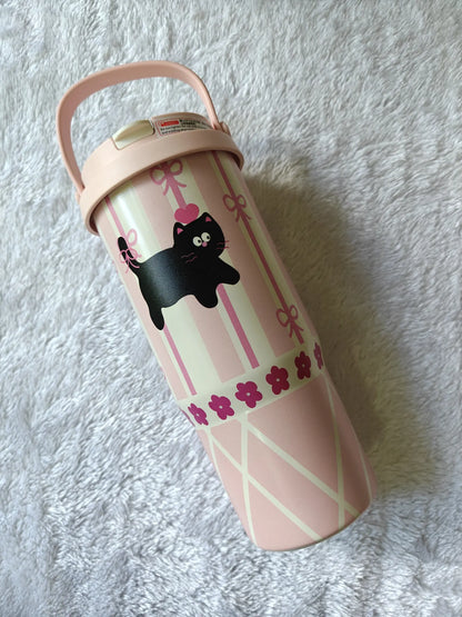 Pink tumbler with black cat design on a white textured background