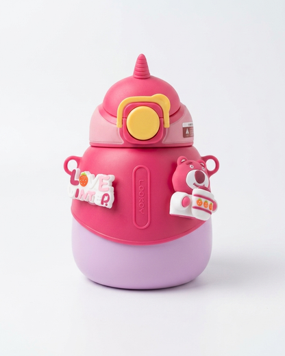 A pink and lavender water bottle with a cute character design, featuring a yellow circular button on the lid, side handles, and decorative stickers, shown on a clean white background.