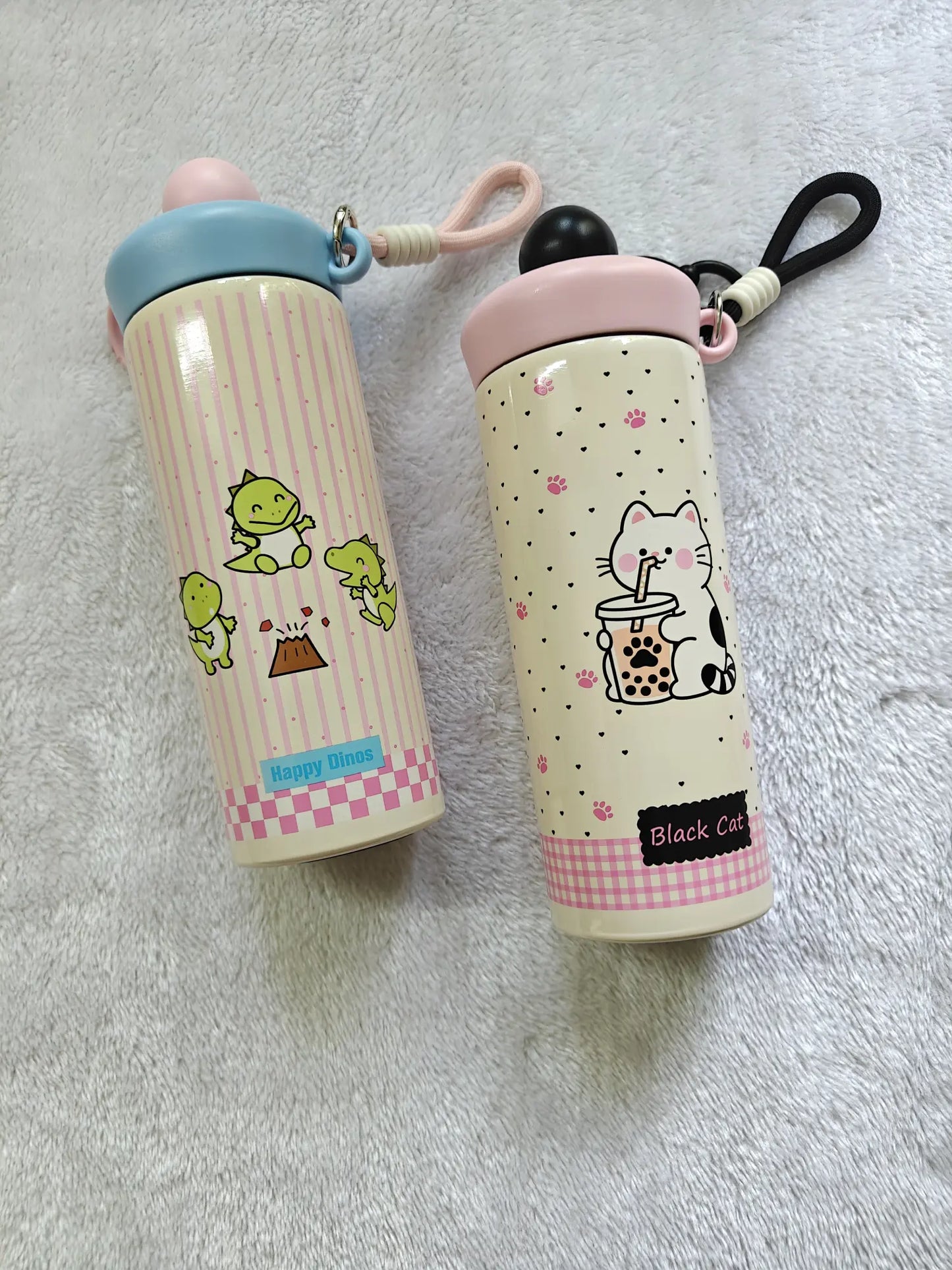 Two cartoon-themed water bottles on a gray surface