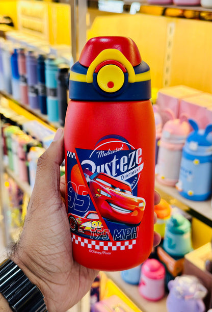 Colorful bottle with a character design held by a hand in a store setting