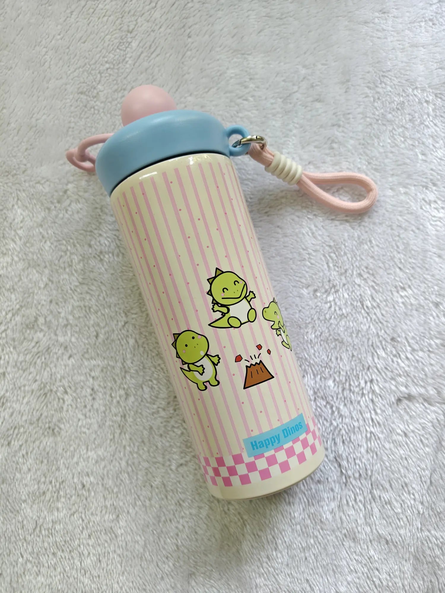 Children's thermos bottle with cartoon designs on a textured surface