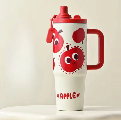 White tumbler with red apple design and handle on a beige background