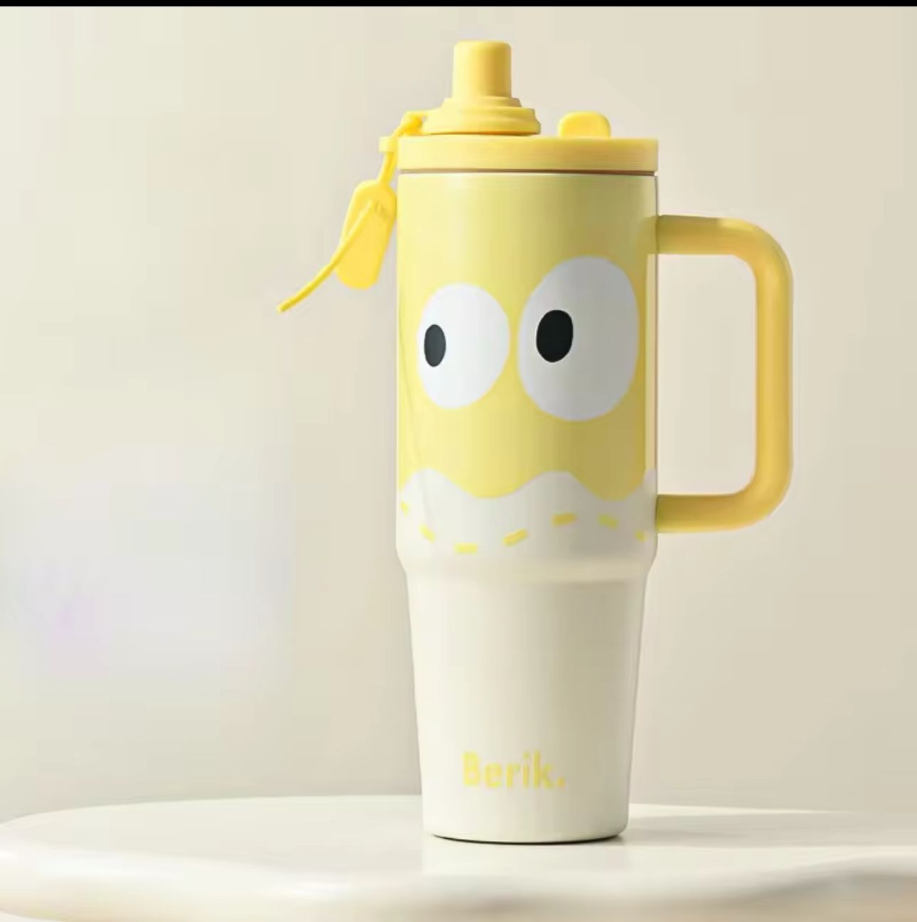 Yellow mug with cartoon face design on a light background