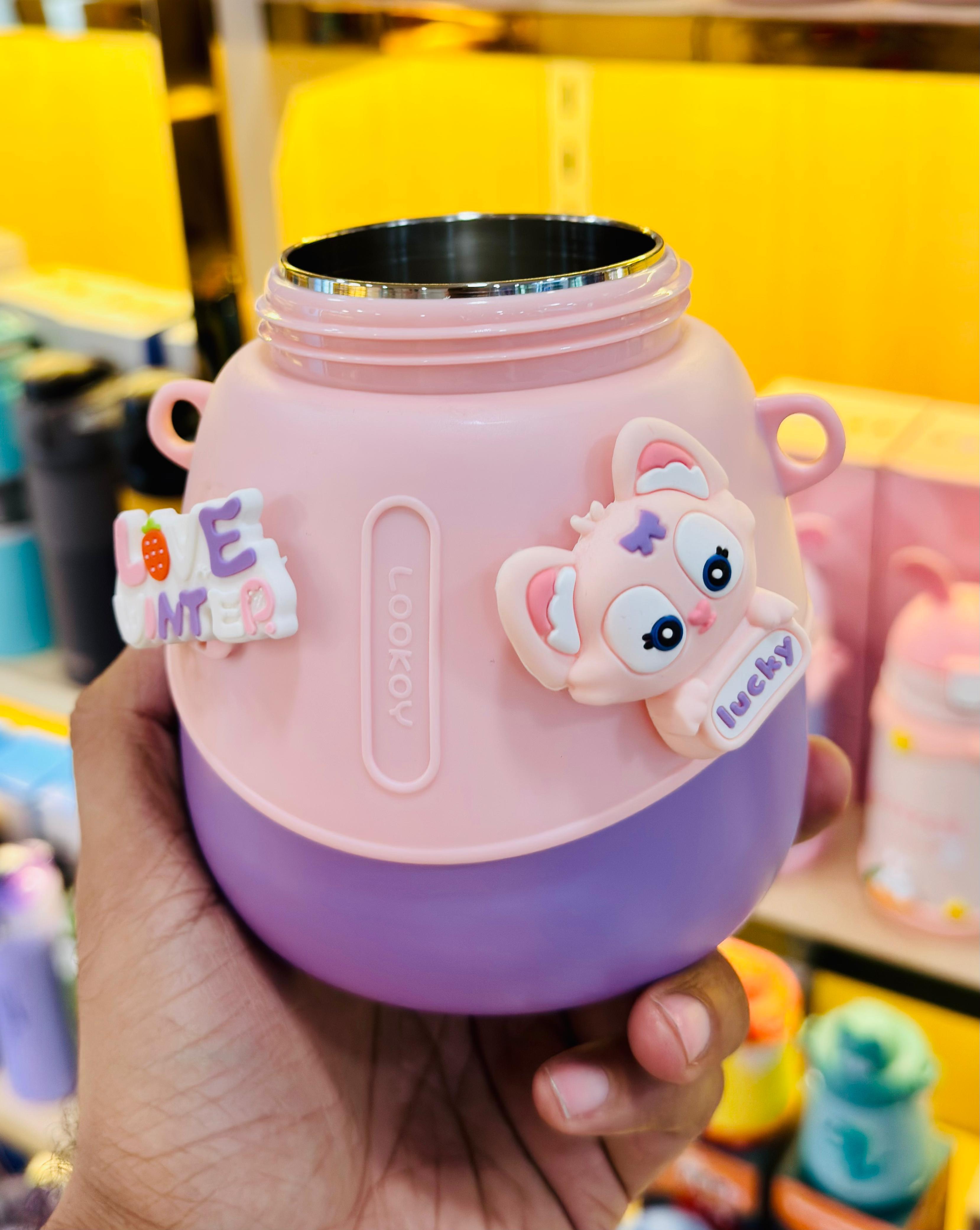 Pink children's thermos with cartoon character on a blurred background