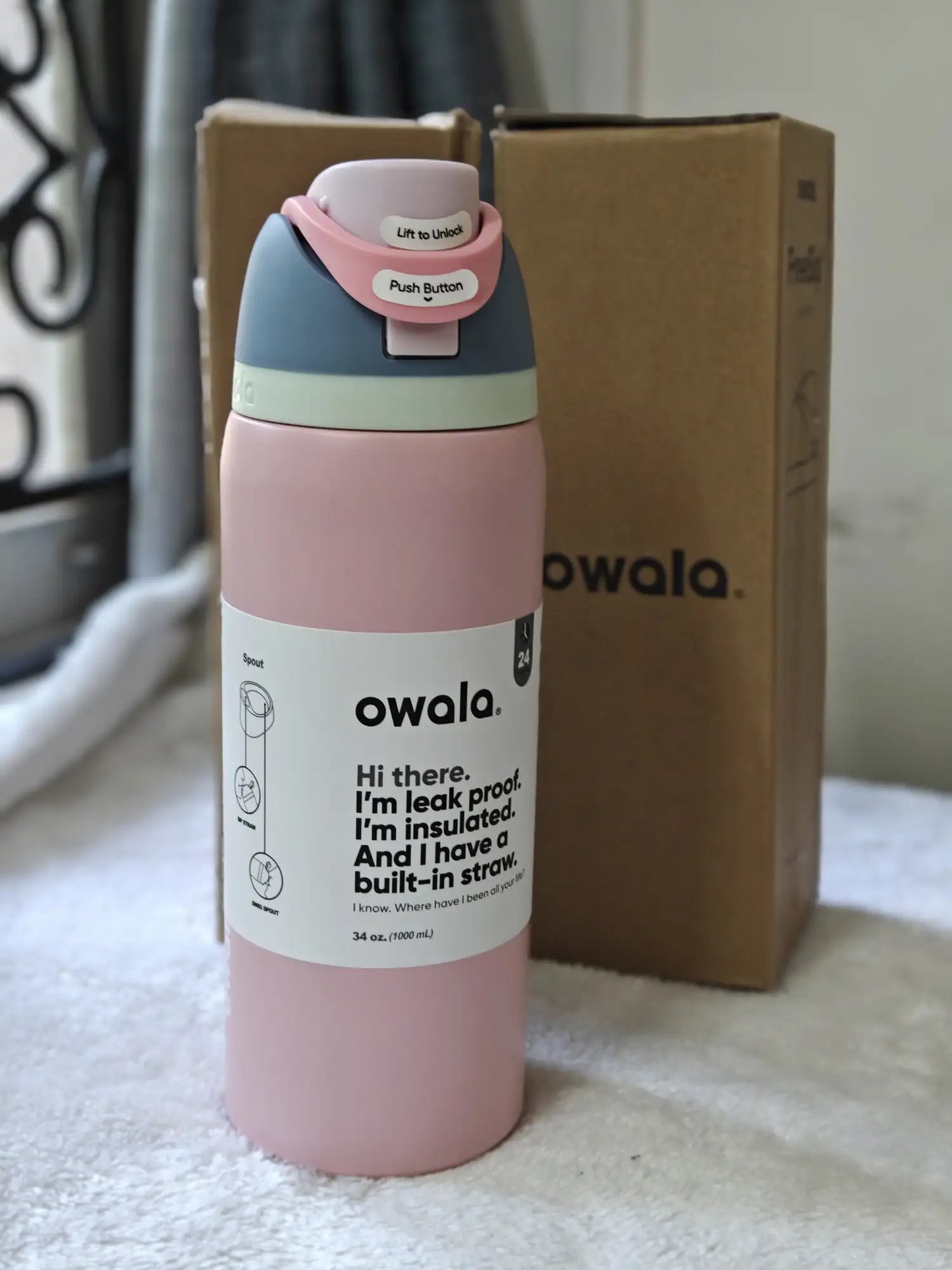 Pink Owala water bottle with a cardboard box in the background