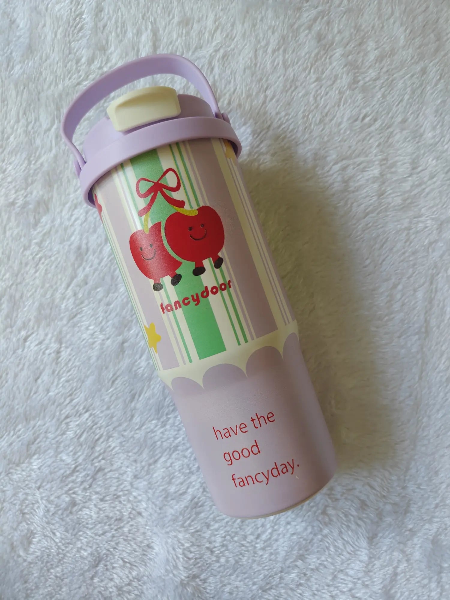 Children's water bottle with apple design and text on a white textured background