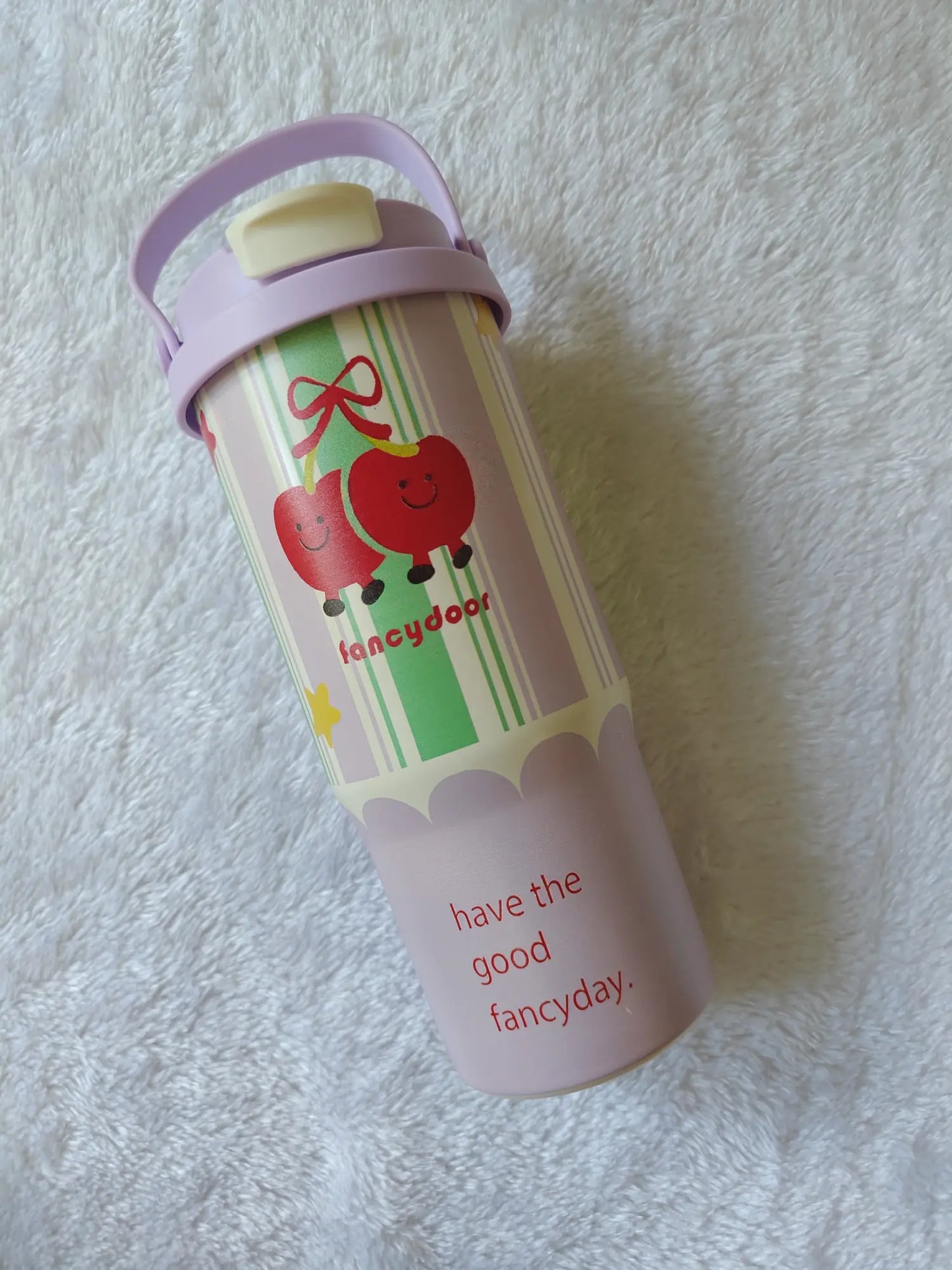 Children's water bottle with apple design and text on a white textured background