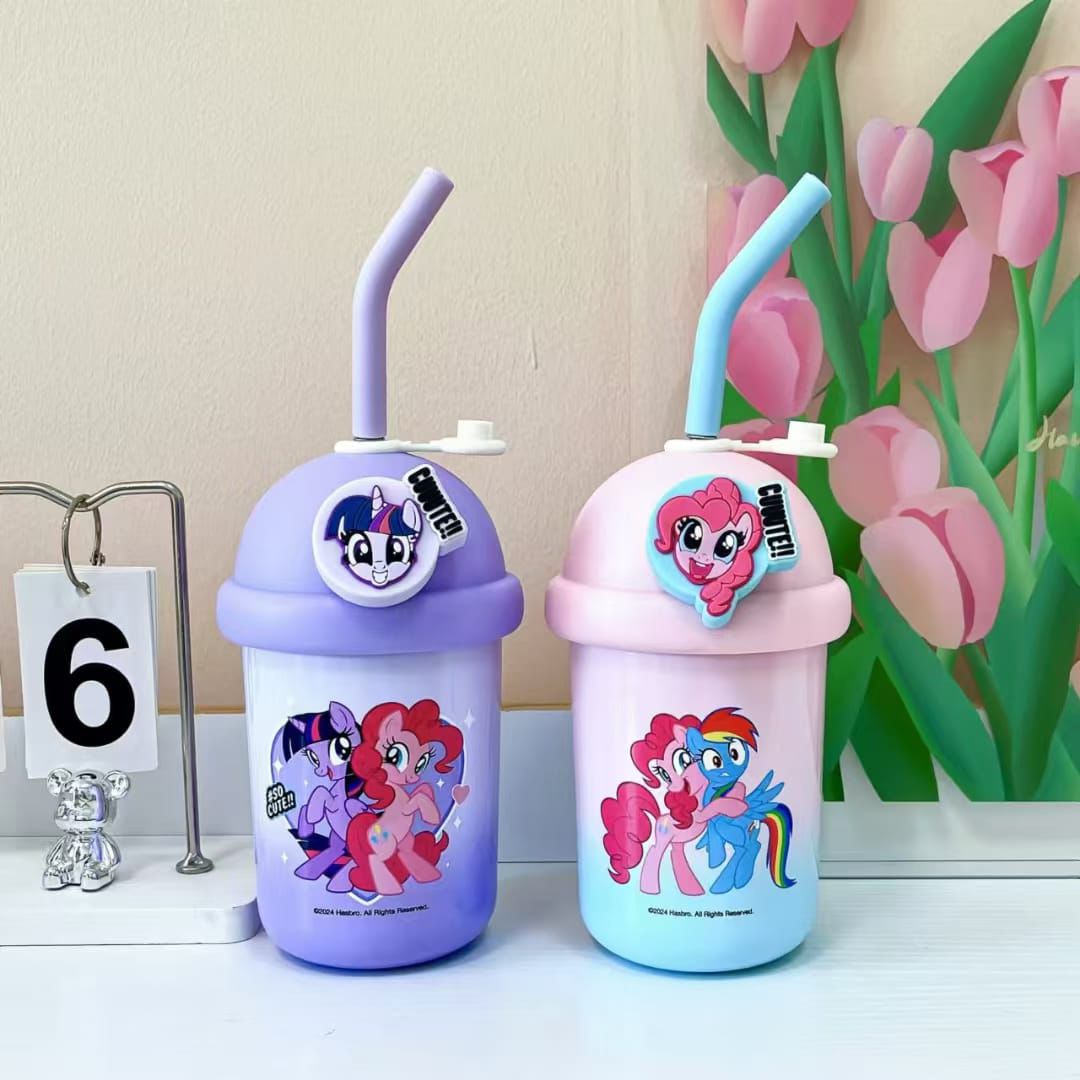 Two children's water bottles with cartoon designs on a white surface with a floral background.