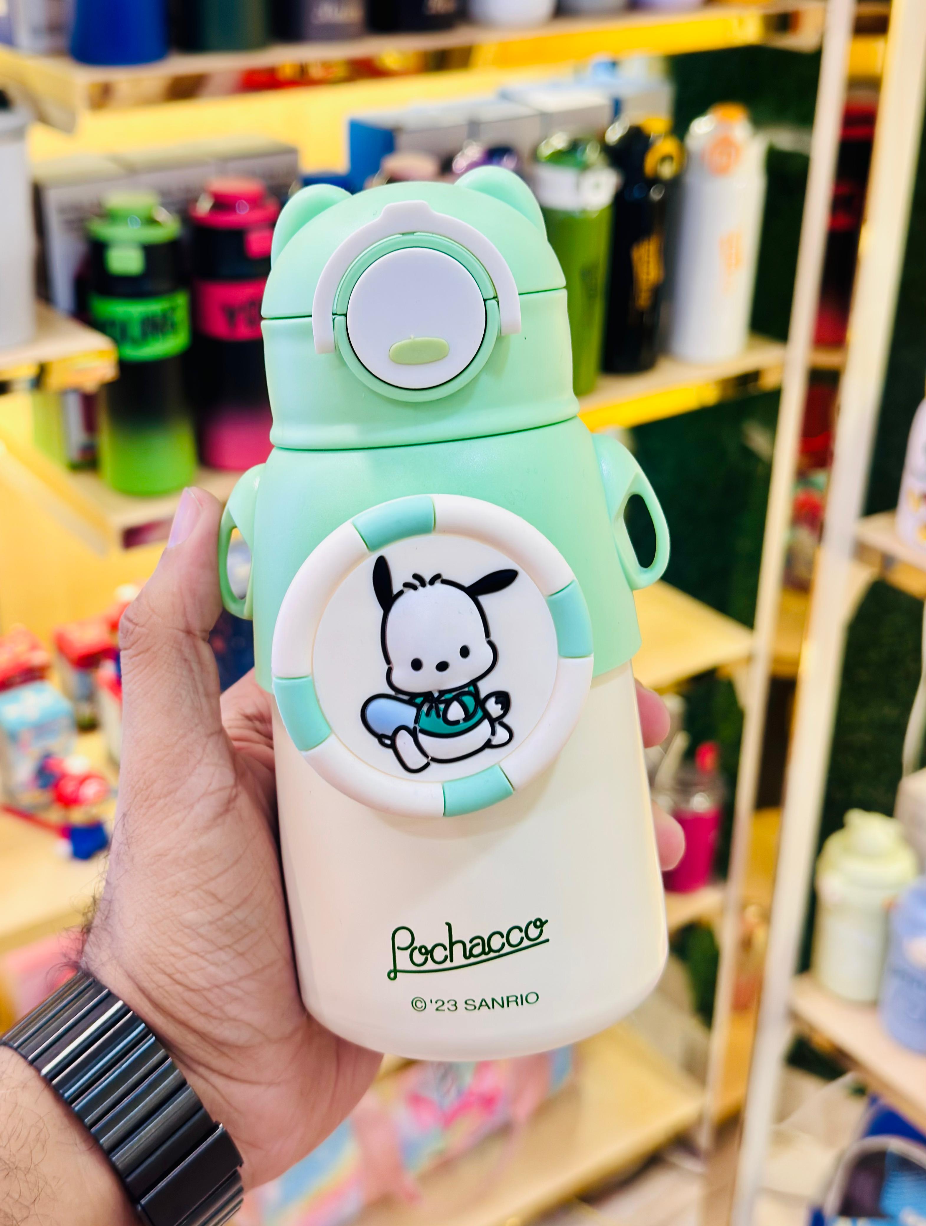 Light green and white tumbler with cartoon character design held by a hand in a store setting.