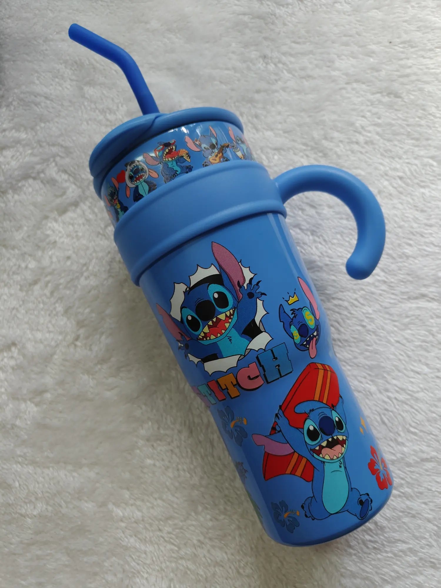 Blue tumbler with cartoon character design on a white textured surface