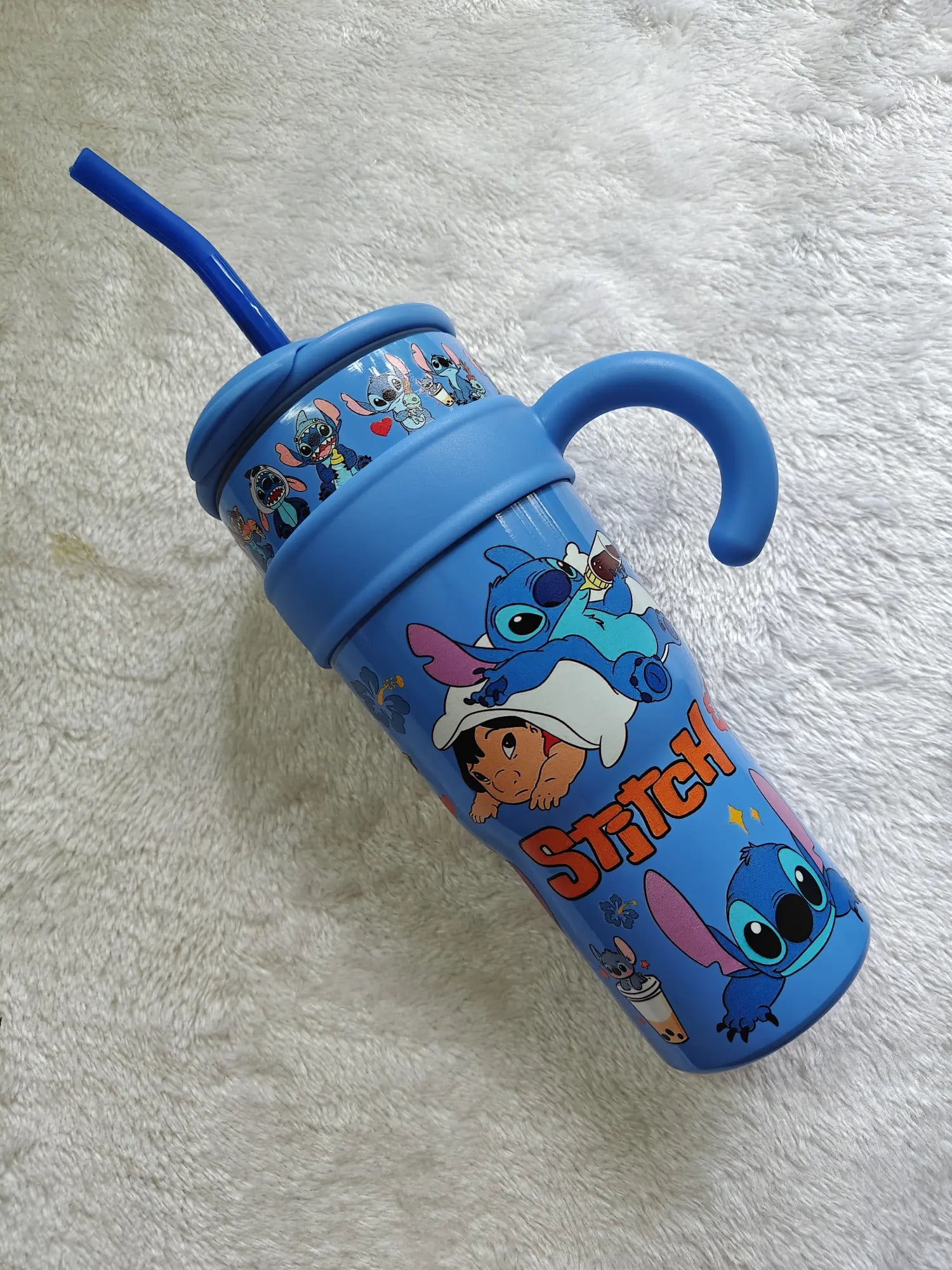 Blue tumbler with cartoon characters on a white textured background