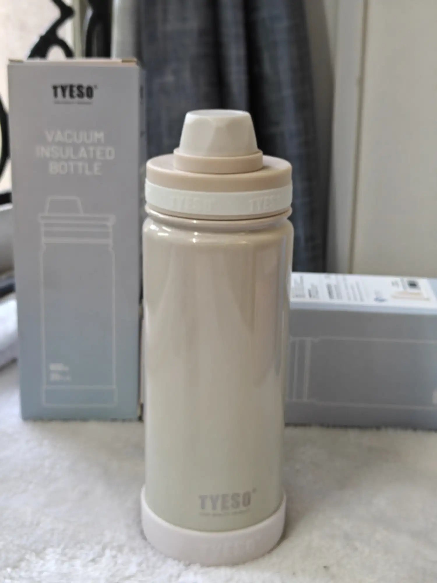 Beige vacuum insulated bottle with TYESO branding on a white surface.