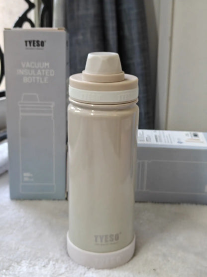 Beige vacuum insulated bottle with TYESO branding on a white surface.
