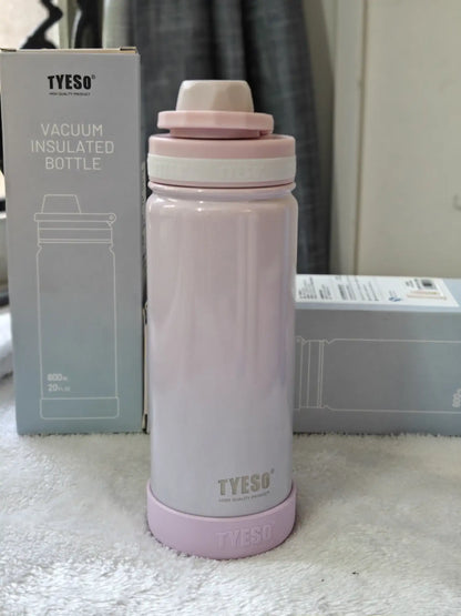 Pink vacuum insulated bottle with TYESO branding next to its packaging on a white surface.