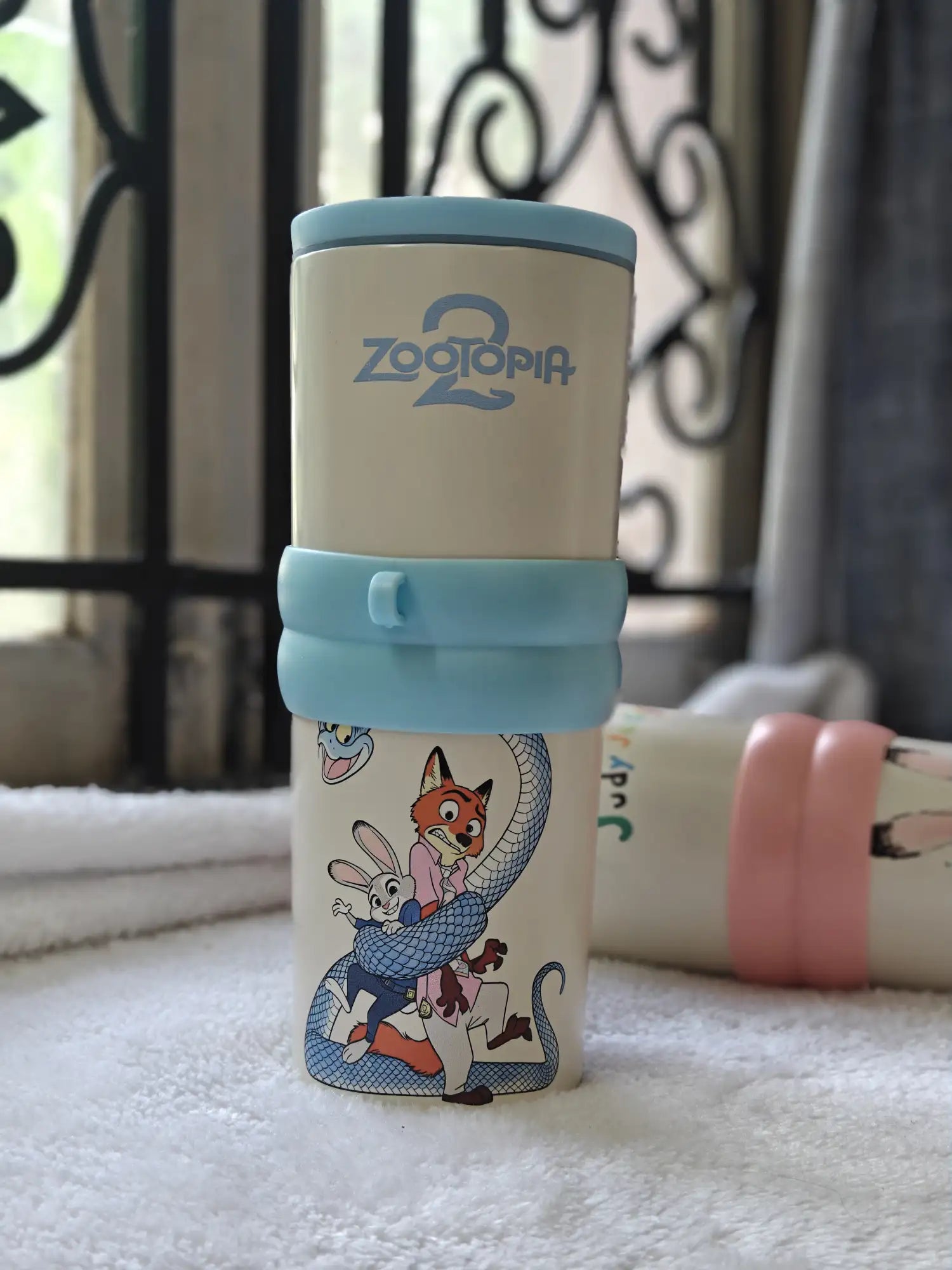Children's cup with Zootopia branding on a textured surface