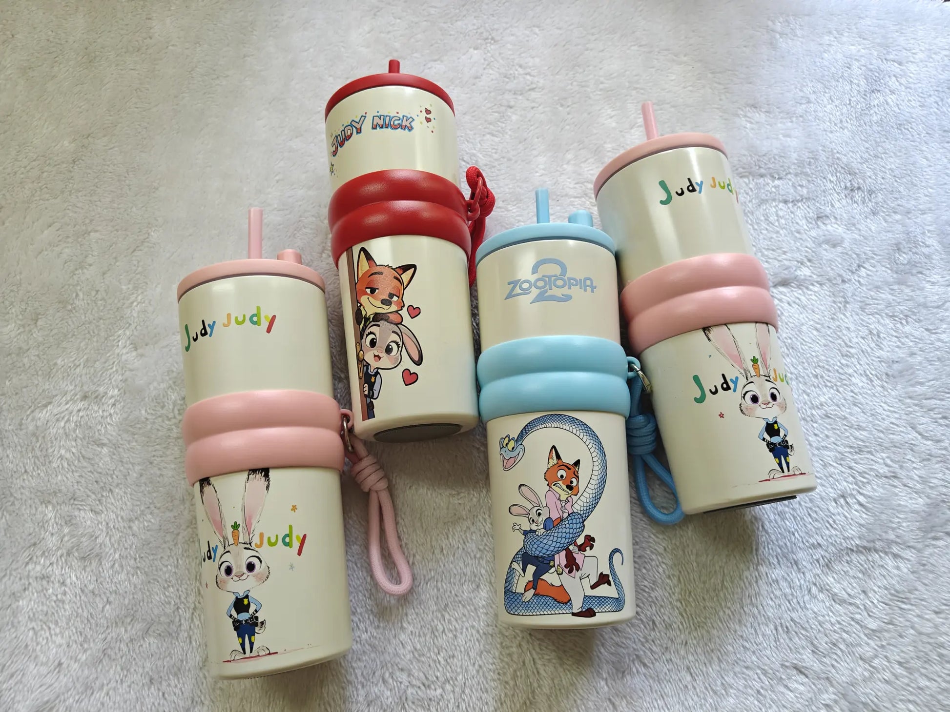 Set of cartoon-themed cups and bottles on a textured surface