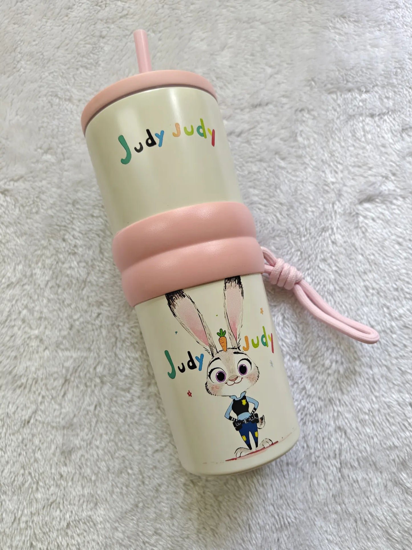 Tumbler with cartoon character and 'Judy Judy' text on a textured surface